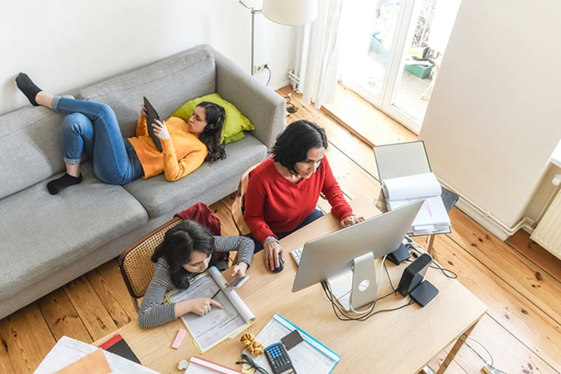 family sitting in living room studying together.